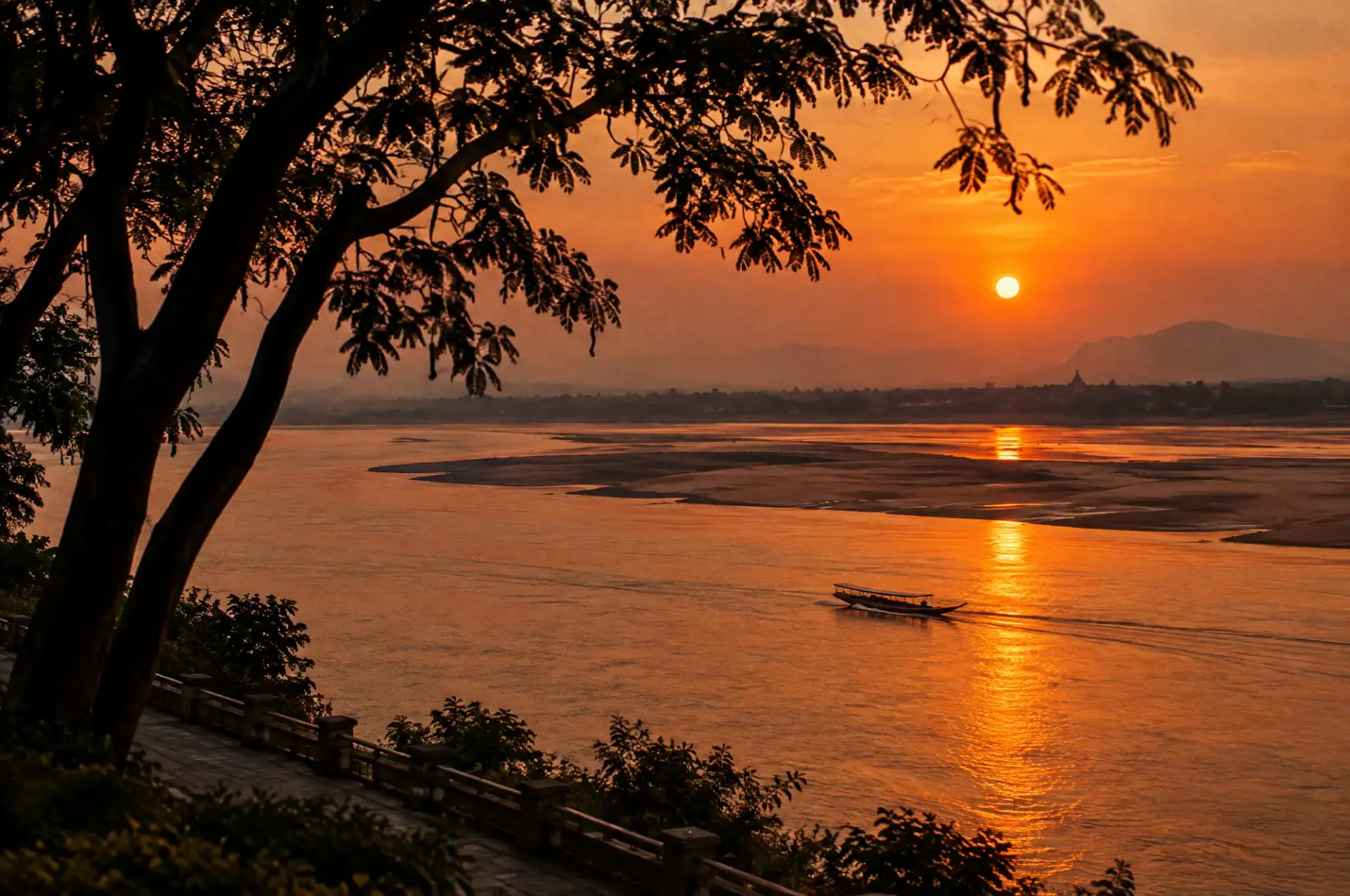 Sunset over the Mekong with a long-tail boat crossing